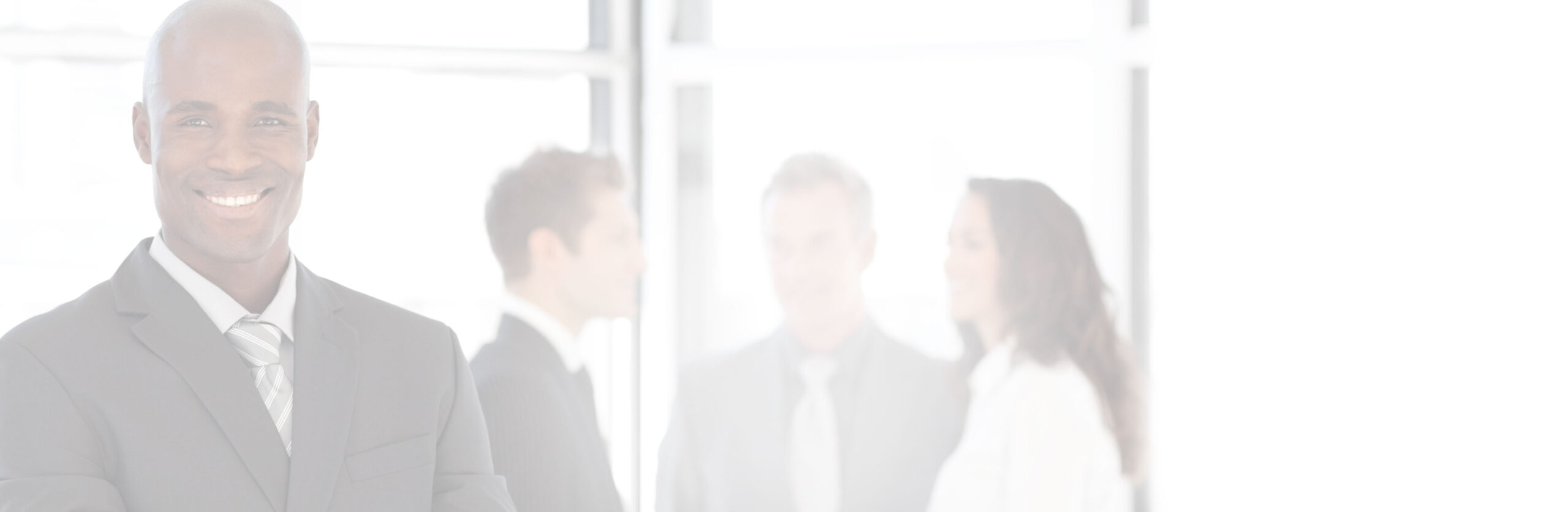 Businessman in suit with three people behind him